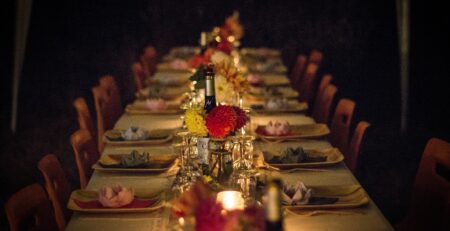 A long farmer's-style table is set outdoors for an event.