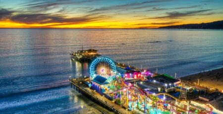 An aerial shot of the famous Santa Monica Pier in Southern California with a colorful sunset over the ocean.