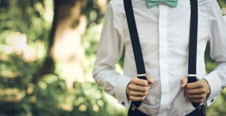 A person in green bow tie and suspenders is seen from neck to navel. The Benefits of Hiring Professional Budtenders for Your Weed Bar Service image.